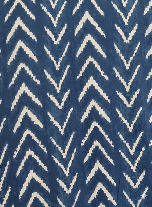 Close-up of soft denim blue rayon challis fabric featuring a white geometric chevron or herringbone print.