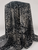 A draped display of black and tan animal print Yoryu chiffon crinkle fabric over a pedestal, showcasing its lightweight, sheer quality and elegant flow