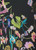 Close-up of sheer black Yoryu chiffon fabric with a vibrant neon floral botanical print in pink, lime green, and lavender.