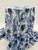 Light blue and slate watercolor floral Yoryu crinkle chiffon fabric draped on a professional display for apparel design.