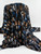 A professional studio shot of Midnight Floral Devoré fabric, featuring a luxurious stretch velvet burnout design with blue and bronze botanical patterns on a black sheer mesh.