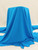 Blue Milly Italy Cady Stretch Suiting fabric with elegant drape on a simple background.