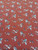 Detailed close-up shot of Rust Floral Rayon Challis fabric, highlighting the fine woven texture and the intricate cream, powder blue, and tan mini floral print.