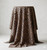 A length of leopard-print rayon challis fabric draped elegantly over a cylindrical pedestal, highlighting the soft, flowing nature and matte texture of the material with its deep black spots set against a warm tan background.