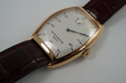 A fine preowned Franck Muller Jump Hour reference 2852HS in 18k rose gold, crafted during the mid 1990s. A handsome accessory that weighs substantially on the wrist with a great vintage style in an updated tonneau 31 mm rose gold case and 11 mm elevated profile paired with a complementary bordeaux alligator strap. Features a subtle guilloche silvered dial, hour aperture, red Arabic hour markers, blued steel minute hand, and black minute track. Suitable for all dress occasions with a luxurious touch.
