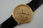 A fine Corum 20 Dollar Coin watch in 18k yellow gold, crafted during the 1990s. USA coin from 1897 exhibits little wear, with the classic ridged coin case and diamond crown. Durable for everyday wear, features a date aperture and black hands contrasting delightfully against the gold face, paired with a glossy alligator black strap. Modeled on 6 inch wrist.

Box included.
Original dial, hands and crown. 
Case measures 36 x 42 mm, 6 mm thick. 
Corum quartz, 10 jewels 
Case# 3763xx Movement# 2194xx
Sapphire crystal. 
Corum black alligator strap, unused.
Corum plated buckle. 
20mm lug width.
