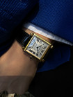A fine preowned Cartier Tank Obus 2380 in 18k yellow gold, crafted circa 1998. The Obus is an iteration of the century-old Tank from Cartier, the name deriving from the French word “bullet” referencing the bullet-shaped lugs. The case sits prominently on the wrist without overwhelming the wearer, encompassing the silver guilloche dial, blued breguet hands black Roman numerals and blue sapphire cabochon crown. From the Collection Privée Cartier Paris line, the exhibition case back reveals the Cartier movement with special attention to interlocking C logo design making this an excellent piece for the collector’s repertoire. Modeled on 6 inch wrist.