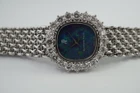 A fine vintage Audemars Piguet opal and diamond bracelet watch in 18k white gold, crafted during the 1980s. A stunning oval accessory for the fiery gem quality opal dial Audemars is renowned in selecting for their fine pieces, surrounded by round brilliant cut diamonds. Both the opal and diamonds catch the light in a way that refracts a glitter of rainbow colors. This piece will dazzle the wearer and suit a variety of occasions, its interlinked chain bracelet wearing comfortably on the wrist. Modeled on 6 inch wrist.

The opal has faint crack at 4 o’clock position that is imperceptible with the naked eye due to the competing opal. Light scratch on center crystal. 
Factory round cut .10 carat diamond set bezel; 2 carats total approximate.
Original opal dial, hands and crown. 
Case measures 21.5 x 22.5 mm, 6.5 mm thick. 
AP cal. 2430, 18 jewel backwind set movement. 
Case# 194xx Movement# 2636xx
Sapphire crystal. 
AP signed bracelet, measures and fits 6 3/4 inches or 17cm approximate, 12mm wide.