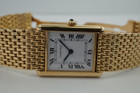 A fine preowned Cartier Tank Grains of Rice in 18k yellow gold, crafted during the 1990s. A special edition of the popular and enduring Tank model for its bracelet charmingly described as grain or beads of rice. The classic white Roman dial with blued steel hands paired with the bracelet serves a dressy look, alternatively a leather strap will tone it down  for more casual feel. Wonderfully drapes the wrist and is comfortable to wear, suitable for men or woman. Modeled on 6 inch wrist.

Light scratches and small nick on crystal. 
Original dial, hands and sapphire crown. 
Case measures 23.5 x 31 mm, 6 mm thick. 
Sapphire crystal. 
Cartier quartz movement. 
Serial# 810522xxx
Cartier bracelet has been previously fitted. Fits 6 1/2 inch or 17 cm approximate.
New non-Cartier black leather strap.
17.5 wide.