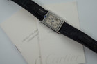 A nice preowned Cartier Basculante reference 2386 with Cartier papers, crafted circa 2001. This is a curious design modeled after their first Cabriolet model from 1932 for its intended functionality during physical activity, so that the crystal is protected, as such the crown placement is allocated to the 12 o’clock position with a horizontal blue oval cabochon charmingly sitting on top. The dial is the standard silvered dial with black Roman numeral markers and inner chemin de fer minute track, secret Cartier signature at 10 o’clock and blued-steel sword-shaped hands. The inner polished case housing said dial is configured into a swing frame, movable in either forward or reverse direction, revealing double C signatures on the inner case back and a smooth steel topper. While this function may not pertain to today’s needs, it is a fascinating detail that sets it apart from the regular Tank models and manages to sit relatively flush on the wrist.