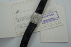 A nice preowned Cartier Basculante reference 2386 with Cartier papers, crafted circa 2001. This is a curious design modeled after their first Cabriolet model from 1932 for its intended functionality during physical activity, so that the crystal is protected, as such the crown placement is allocated to the 12 o’clock position with a horizontal blue oval cabochon charmingly sitting on top. The dial is the standard silvered dial with black Roman numeral markers and inner chemin de fer minute track, secret Cartier signature at 10 o’clock and blued-steel sword-shaped hands. The inner polished case housing said dial is configured into a swing frame, movable in either forward or reverse direction, revealing double C signatures on the inner case back and a smooth steel topper. While this function may not pertain to today’s needs, it is a fascinating detail that sets it apart from the regular Tank models and manages to sit relatively flush on the wrist.