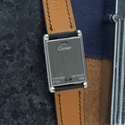 A late 1990s Cartier Tank Basculante in stainless steel, wonderfully constructed in a compact 22mm size. The dark grey patterned dial is contrasted by bright white stylized Arabic numerals and silvered sword-shaped hands, giving the watch a distinctive monochromatic look.
The Basculante's hinged case is the highlight of the design, allowing the watch head to pivot within its frame and turn completely over. It opens and closes smoothly and can remain upright within the frame. A blue cabochon accents the case, while the crown is cleverly concealed and accessed only when the watch is flipped from its usual position.
Powered by a quartz movement and fitted with a custom dark grey Babele leather strap secured by a Cartier stainless steel deployant clasp. An unusual interpretation of the Tank, with much of its appeal found in the ingenious case construction.

Watch Details
Reference: 2386
Case Number: 3514xxxx
Case: Stainless steel
Case Size: 22 × 32 mm; 6 mm thick
Dial: Dark grey patterned dial; white Arabic numerals
Movement: Quartz
Crystal: Sapphire
Strap: Custom dark grey Babele leather, adjustable
Lug Width: 17 mm
Clasp: Cartier stainless steel deployant
Wrist Size: Fits up to approximately 6 1/2 inches
Modelled On: 6-inch wrist
Condition: Light wear shown
Service: New battery installed