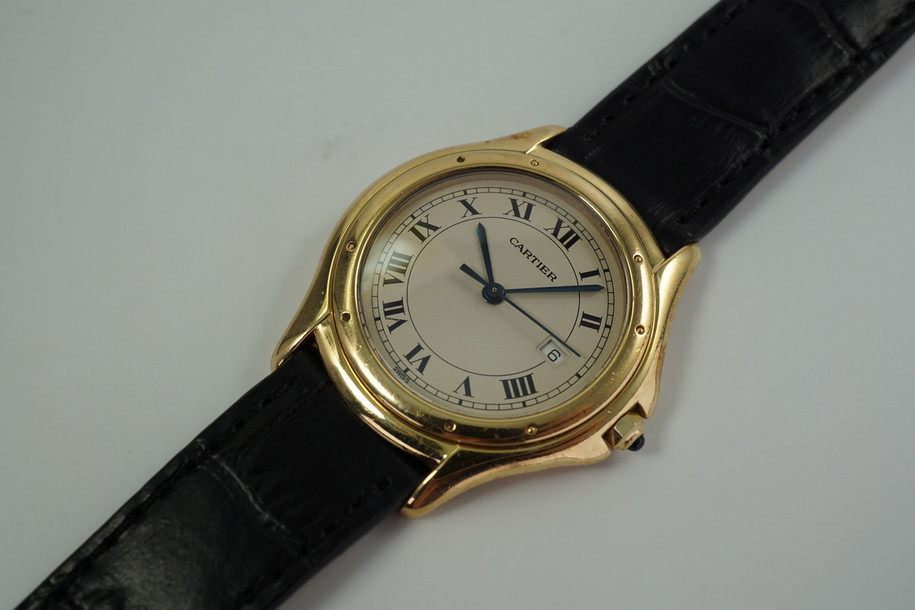 A fine preowned Cartier Cougar Panthere reference 887904 in 18k yellow gold , crafted during the 1990s. Features the standard white dial with a slight patina, black Roman numeral hours and thin outer minute railroad track, date aperture in place of the 3 o’clock, and blued-steel sword-shaped hands. The 32mm round case will suit a man or woman’s wrist, paired with a black leather strap suiting a variety of settings sitting comfortably with its 6 mm silhouette. 

Slight tarnish and scratches.
Original dial, hands and Cartier crown.
Sapphire crystal.
Case measures 32 x 38mm, 6 mm thick.
Cartier quartz jeweled movement.
Serial# 1404xxx
New premium non-Cartier black leather strap.
Cartier plated buckle.
16mm lug width.