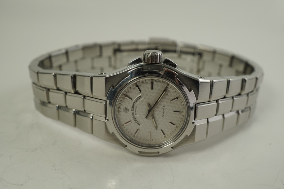 A fine Vacheron Constantin Overseas reference 12050 in stainless steel, crafted during the 2000s. The 24mm tonneau case holds an interesting 8-sided bezel encasing a silver guilloche dial with silver faceted arrow stick hour markers with lume arrows and pointed stick hands with lume in middle, notched crown and a fully integrated bracelet with a double folding clasp. Lends to a great sporty accessory for casual moments. 

Scratches throughout.
Case measures 24 x 29 mm.
Sapphire crystal. 
Vacheron cal., 7 jewels quartz movement. 
Serial# 698xxx Movement# 802xxx
Vacheron steel double folding clasp bracelet, fits 6.5 inches approximate.
16mm lug width.