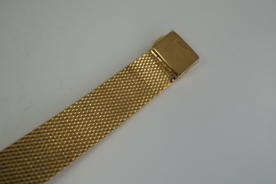 A very nice vintage Movado bracelet watch in 18k yellow gold, crafted during the late 1960s. Once retailed by Cartier, the subtle hexagonal polished case with original finish is surrounded by 28 diamonds weighing 1.12 carat total weight, houses a silver dial signed Cartier with black stick and Roman numerals and stick hands. Resembling a floral design further accentuated by a beautifully crafted integrated bracelet with a backwind function that adds to its daintiness. Suitable for casual and dressy occasions.