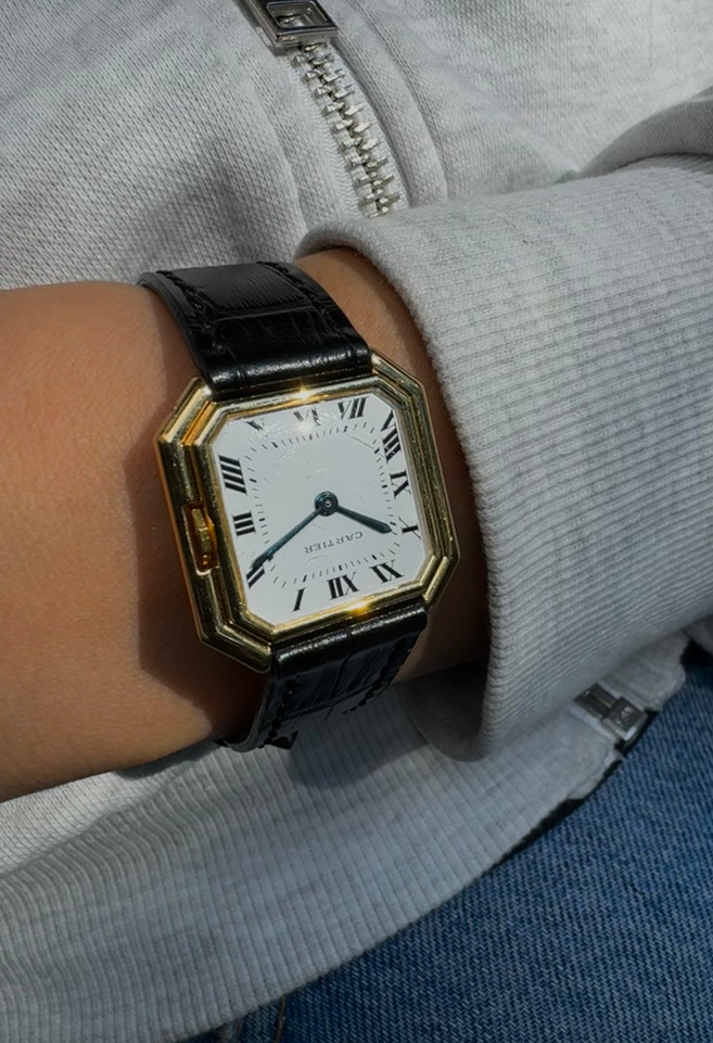 A fine Cartier Ceinture large in 18k yellow gold from the early 1970s. The case and movement are both exquisitely crafted and the hexagonal gold crown adds a fun touch to the stepped case. This piece would suit either a man or woman for a variety of settings.

Sapphire crystal shows light scratches. 

Dial has been refinished long ago.

Polished case with French hallmarks.

Jaeger caliber Cartier 18 jewel movement, mechanical wind.

Non-Cartier 16mm black leather strap. 

16 mm between lugs.