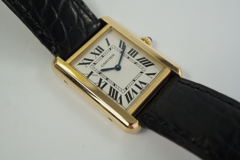 A very nice preowned Cartier Tank Solo reference 3168-W5200002 in 18k yellow gold Cartier Tank Solo, crafted circa 2010s.  An enduring classic with simple rectangular softly edged case housing a white dial and black Roman numeral hour markers with inconspicuous Cartier logo at 10 o’clock, black inner minute track and blued-steel sword-shaped hands and blue spinel beaded crown. Paired with the black crocodile strap, will suit a variety of settings, sitting comfortably on the wrist with its 5mm silhouette.

Original dial, hands and Cartier sapphire crown.
Sapphire crystal.
Case measures 24.5 x 31mm, 5 mm thick.
Cartier quartz movement.
Serial# 7628XXXX
Cartier black alligator strap (85% condition).
Cartier 18k tang buckle.
18mm lug width.