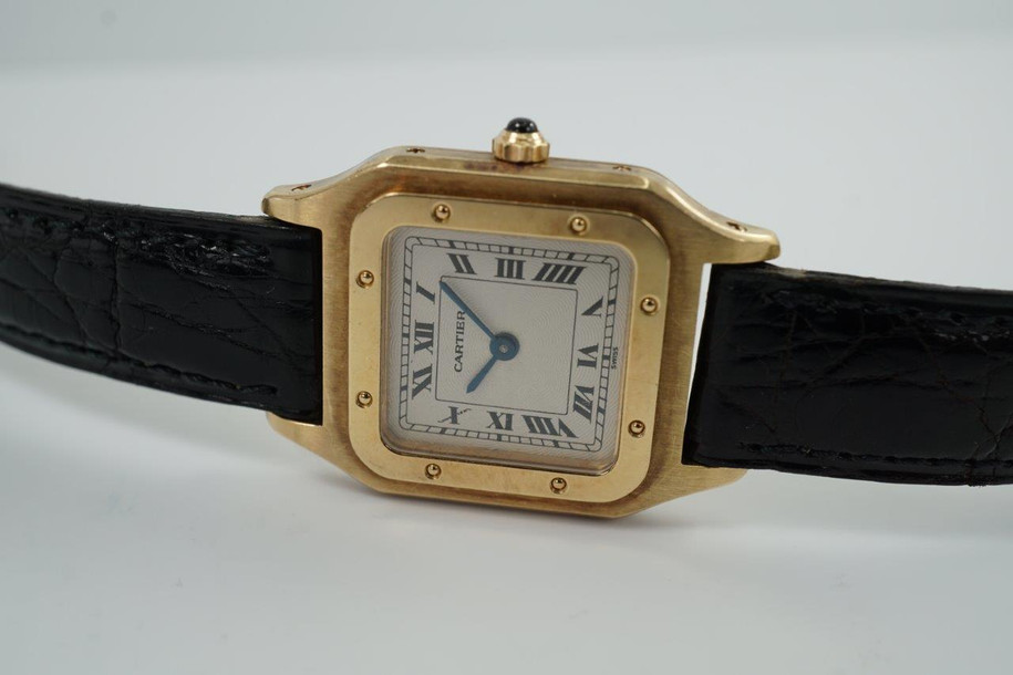 BRAND:                            Cartier 
MODEL:                            Santos Dumont  
CASE MATERIAL:            18k Yellow Gold
CASE MEASURES:          23 x 32 mm
MOVEMENT:                     Mechanical
FUNCTIONS:                    Time
CONDITION:                     Very good
See it in our eBay store.
A beautiful Cartier Santos Dumont Extra Plate in 18k yellow gold, crafted during the 1990s. This model is in a size that is a nice in-between, wearing minimally on the wrist with its thin profile, catching the light at times with the polished finish of the bezel. The contrasting polishes of the case and bezel almost gives it a two-tone effect, further accentuated with the beautiful guilloche dial. Modeled on size 6 inch wrist. 

Light scratches and nicks.
Original dial, hands and crown.
Case measures 23 x 32 mm, 4mm thick.
Cartier cal. 21, 17 jewels mechanical winding.
Serial# 8210530xxx
Sapphire crystal.
Cartier black alligator strap (85% condition).
Cartier 18k gold buckle. 
13 mm lug width.