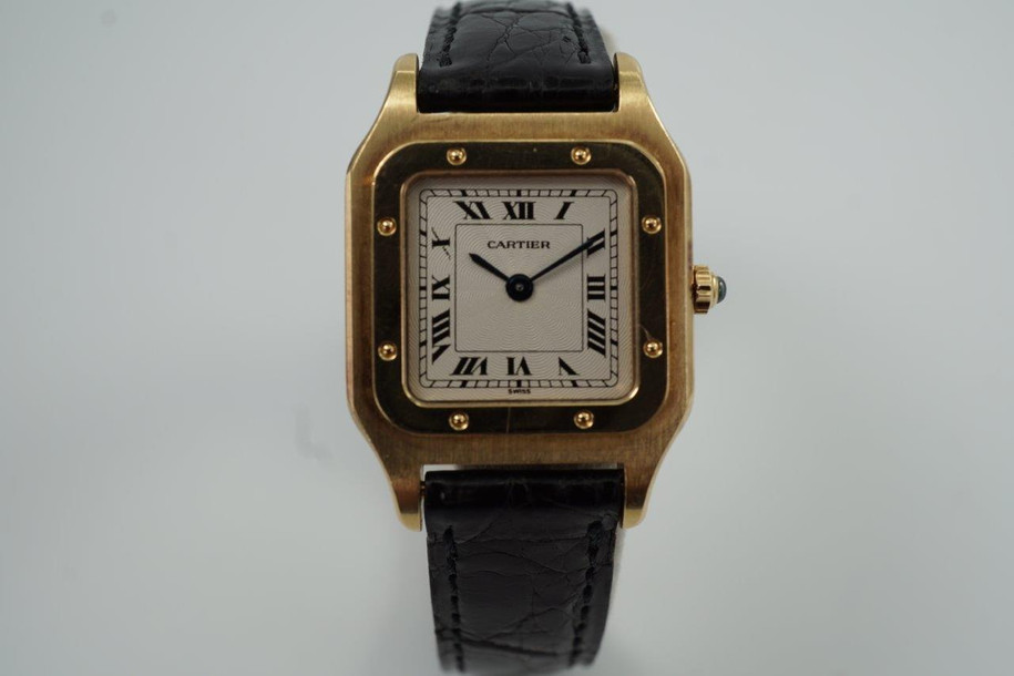 BRAND:                            Cartier 
MODEL:                            Santos Dumont  
CASE MATERIAL:            18k Yellow Gold
CASE MEASURES:          23 x 32 mm
MOVEMENT:                     Mechanical
FUNCTIONS:                    Time
CONDITION:                     Very good
See it in our eBay store.
A beautiful Cartier Santos Dumont Extra Plate in 18k yellow gold, crafted during the 1990s. This model is in a size that is a nice in-between, wearing minimally on the wrist with its thin profile, catching the light at times with the polished finish of the bezel. The contrasting polishes of the case and bezel almost gives it a two-tone effect, further accentuated with the beautiful guilloche dial. Modeled on size 6 inch wrist. 

Light scratches and nicks.
Original dial, hands and crown.
Case measures 23 x 32 mm, 4mm thick.
Cartier cal. 21, 17 jewels mechanical winding.
Serial# 8210530xxx
Sapphire crystal.
Cartier black alligator strap (85% condition).
Cartier 18k gold buckle. 
13 mm lug width.
