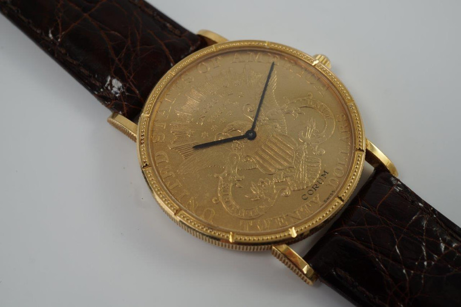 BRAND:                            Corum 
MODEL:                            $20 Liberty
CASE MATERIAL:            18k yellow gold 
CASE MEASURES:          35.5 x 42 mm
MOVEMENT:                     Mechanical winding
FUNCTIONS:                    Time 
CONDITION:                     Fine
See it in our eBay store.
A fine preowned Corum 20 Dollar Liberty Coin watch in 18k yellow gold, crafted during the 2000s. A collectible piece to add to your collection, the back bears the year 1878. Makes a lovely golden statement on the wrist for a variety of settings. Modeled on a 6 inch wrist. 
Light scratches.
Original dial, hands, diamond crown. 
Case measures 35.5 x 42 mm, 5 mm thick. 
Corum cal., 18 jewels mechanical winding.
Serial# 592501
New non-Corum brown leather strap.
Corum 18k gold buckle.
20 mm between lugs.