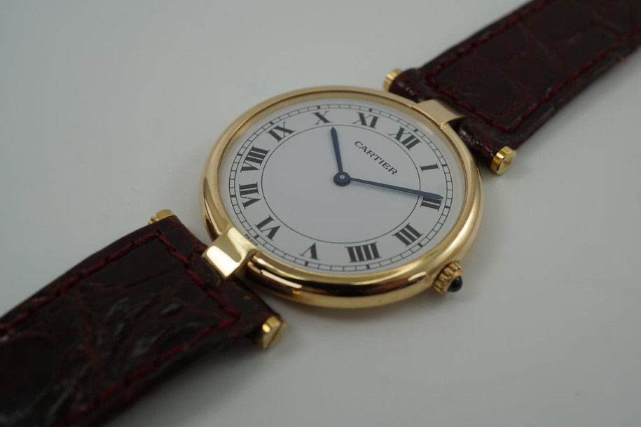 BRAND:                           Cartier
MODEL:                           Vendome 
CASE MATERIAL:           18k yellow gold
CASE MEASURES:          30 x 37 mm
MOVEMENT:                   Quartz  
FUNCTIONS:                   Time 
CONDITION:                    Excellent
See it in our eBay store.

A nice Cartier Vendome in 18k yellow gold, crafted during the 1990s. An everyday accessory that suits various wrist sizes with its minimal ultra thin round profile and case size. This piece was been serviced by Cartier ($375 value), quartz movement and hands have been replaced and includes Cartier service box and papers. Modeled on size 6 inch wrist.

Small ding on case by crown, light scratches. 
Original white Roman dial, blue steel hands and sapphire crown. 
Case measures 30 x 37 mm.
Cartier quartz movement.
Case# 810011604
Cartier 16mm burgundy crocodile strap (80% condition approx.).
Cartier gold plated buckle. 
16mm lug width.