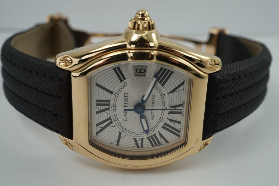 BRAND:                            Cartier
MODEL:                            Roadster
CASE MATERIAL:            18k yellow gold
CASE MEASURES:          36 x 44 mm
MOVEMENT:                     Automatic
FUNCTIONS:                    Time and date 
CONDITION:                     Very good
See it in our eBay store.
A fine Cartier Roadster in 18k yellow gold reference 2524, crafted in the 2000s. A classic model with silver/white Roman dial, lume hands and gold screw down crown. Great size fit without an overwhelming profile, suitable for various occasions. Modeled on a 6 inch wrist. 

Scratches on case. 
Original silver/white Roman dial, lume hands and gold Cartier screw down crown. 
Sapphire crystal.
Cartier caliber, highly jeweled automatic winding. 
Serial# 8527xxxD
Cartier black coated canvas adjustable strap.
Cartier 18k gold deployment buckle.
19 mm between flexible lugs.