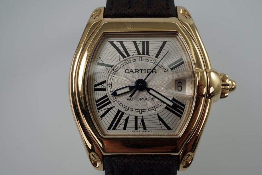 BRAND:                            Cartier
MODEL:                            Roadster
CASE MATERIAL:            18k yellow gold
CASE MEASURES:          36 x 44 mm
MOVEMENT:                     Automatic
FUNCTIONS:                    Time and date 
CONDITION:                     Very good
See it in our eBay store.
A fine Cartier Roadster in 18k yellow gold reference 2524, crafted in the 2000s. A classic model with silver/white Roman dial, lume hands and gold screw down crown. Great size fit without an overwhelming profile, suitable for various occasions. Modeled on a 6 inch wrist. 

Scratches on case. 
Original silver/white Roman dial, lume hands and gold Cartier screw down crown. 
Sapphire crystal.
Cartier caliber, highly jeweled automatic winding. 
Serial# 8527xxxD
Cartier black coated canvas adjustable strap.
Cartier 18k gold deployment buckle.
19 mm between flexible lugs.