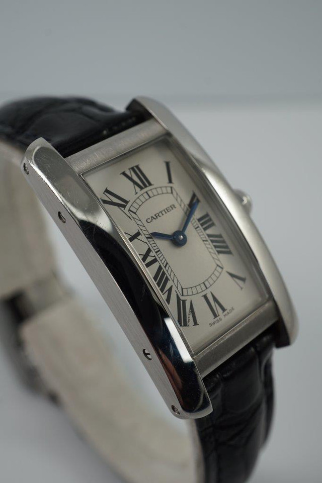 BRAND:                           Cartier
MODEL:                           Tank Americaine
CASE MATERIAL:            Stainless steel 
CASE MEASURES:          19 x 35 mm
MOVEMENT:                     Quartz
FUNCTIONS:                    Time
CONDITION:                     Very good
See it in our eBay store.
A fine preowned Cartier Tank Americaine reference 3970 in stainless steel, crafted circa 2020.  Classic minimal style with the white dial in stainless steel case and black leather strap that would suit a variety of occasions. Modeled on a 6 inch wrist. 

Light scratches and scuffs.
Case measures 19 x 35, 7 mm thick. 
Cartier caliber quartz movement.
Serial# 1049xxxX
Carter black alligator strap (85% condition).
Cartier steel deployment buckle.
13 mm between lugs.