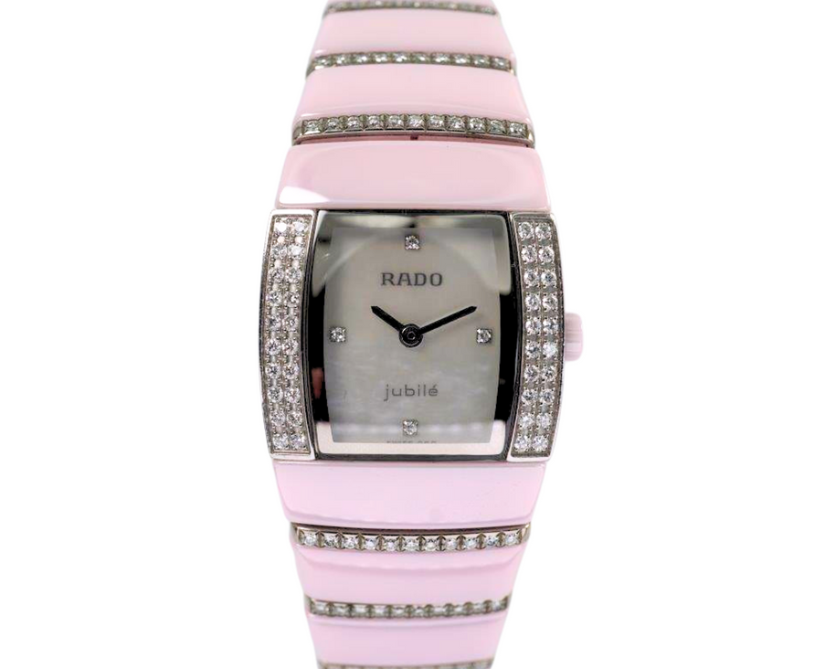 BRAND:                          Rado
MODEL:                          Sintra Jubile 
CASE MATERIAL:           Ceramic and diamond
CASE MEASURES:          22 x 27 mm
MOVEMENT:                   Quartz  
FUNCTIONS:                   Time
CONDITION:                    Fine
See it in our eBay store.

A very nice preowned Rado Sintra Jubilee in ceramic, crafted during the 2010s. A sweet little watch for the wearer who enjoys wearing a delicate pink watch with accented diamond bezel and bracelet, featuring a mother of pearl dial and diamond hour markers. Wears comfortably with its size and weight, and double-fold clasp. The crown is in the shape of a flower that makes this piece extra special. Modeled on size 6 inch wrist.

Minimal scratches. 
Factory diamond bezel, mop diamond dial and 8 rows of graduating diamonds. 
Case measures 22 x 27 mm, 7.5mm thick.
Rado quartz movement.
Serial# 1D118056
Sapphire crystal.
Rado bracelet fits 6 1/2 inches.
18mm graduated bracelet.
Last known retail: 5,600 USD.