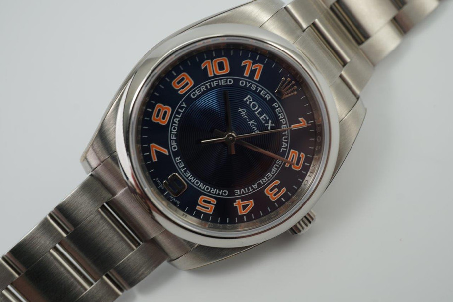 A fine Rolex Air King reference 114200 in stainless steel, dated 2010. This particular sports model is striking for its vivid blue concentric dial and pop of orange hour markers with white accents, a nod to the New York Mets. It appears to be in unworn condition as it has full stickers so we consider this to be a safe queen. Great opportunity to own one in such incredible condition.  Modeled on size 6 inch wrist.

Original dial, hands and crown.
Case measures 35 x 42mm, 12mm thick.
Serial# M4723xx
Rolex steel bracelet contains 12.5 links (full size).
19mm lug width.
Rolex inner and outer green box.
Rolex card and papers.