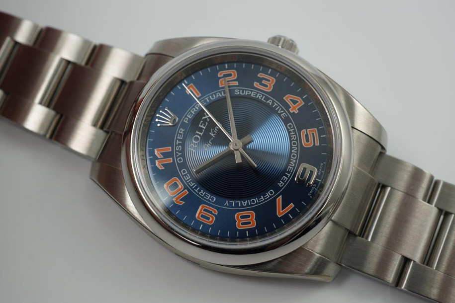 A fine Rolex Air King reference 114200 in stainless steel, dated 2010. This particular sports model is striking for its vivid blue concentric dial and pop of orange hour markers with white accents, a nod to the New York Mets. It appears to be in unworn condition as it has full stickers so we consider this to be a safe queen. Great opportunity to own one in such incredible condition.  Modeled on size 6 inch wrist.

Original dial, hands and crown.
Case measures 35 x 42mm, 12mm thick.
Serial# M4723xx
Rolex steel bracelet contains 12.5 links (full size).
19mm lug width.
Rolex inner and outer green box.
Rolex card and papers.