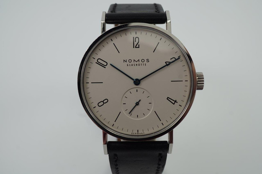 A fine preowned NOMOS Glashutte Tangomat in stainless steel, crafted circa 2008-10. A minimal and sturdy accessory of famed German craftmanship, featuring tonal silver dial with subsidiary dial, blue hands and black markers. The 38mm size circumvents overpowering the wrist while preserving a statement with its slightly bold profile and angular grasshopper-style lugs, with a glass exhibition to the beautiful movement. Modeled on 6 inch wrist.

Minimal wear.
Box and papers included.
Case measures 38 x 48 mm, 8.5 thick.
NOMOS cal., 26 jewel automatic winding. 
Serial# 2645
Sapphire crystal.
NOMOS black Shell Cordovan strap (75-80% condition approximate).
NOMOS steel buckle. 
USD retail approx. 3280 USD
20mm between lugs.