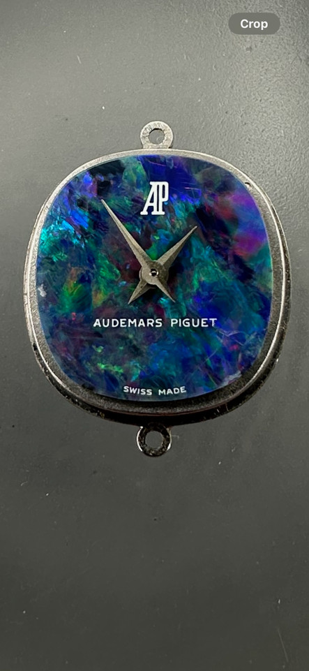 A fine vintage Audemars Piguet opal and diamond bracelet watch in 18k white gold, crafted during the 1980s. A stunning oval accessory for the fiery gem quality opal dial Audemars is renowned in selecting for their fine pieces, surrounded by round brilliant cut diamonds. Both the opal and diamonds catch the light in a way that refracts a glitter of rainbow colors. This piece will dazzle the wearer and suit a variety of occasions, its interlinked chain bracelet wearing comfortably on the wrist. Modeled on 6 inch wrist.

The opal has faint crack at 4 o’clock position that is imperceptible with the naked eye due to the competing opal. Light scratch on center crystal. 
Factory round cut .10 carat diamond set bezel; 2 carats total approximate.
Original opal dial, hands and crown. 
Case measures 21.5 x 22.5 mm, 6.5 mm thick. 
AP cal. 2430, 18 jewel backwind set movement. 
Case# 194xx Movement# 2636xx
Sapphire crystal. 
AP signed bracelet, measures and fits 6 3/4 inches or 17cm approximate, 12mm wide.