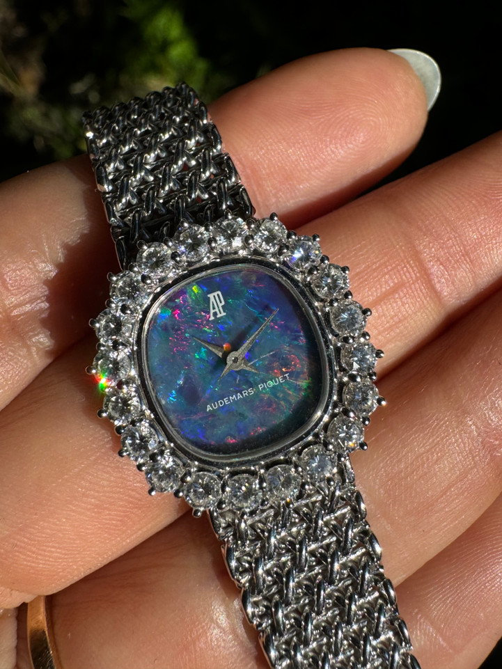 A fine vintage Audemars Piguet opal and diamond bracelet watch in 18k white gold, crafted during the 1980s. A stunning oval accessory for the fiery gem quality opal dial Audemars is renowned in selecting for their fine pieces, surrounded by round brilliant cut diamonds. Both the opal and diamonds catch the light in a way that refracts a glitter of rainbow colors. This piece will dazzle the wearer and suit a variety of occasions, its interlinked chain bracelet wearing comfortably on the wrist. Modeled on 6 inch wrist.

The opal has faint crack at 4 o’clock position that is imperceptible with the naked eye due to the competing opal. Light scratch on center crystal. 
Factory round cut .10 carat diamond set bezel; 2 carats total approximate.
Original opal dial, hands and crown. 
Case measures 21.5 x 22.5 mm, 6.5 mm thick. 
AP cal. 2430, 18 jewel backwind set movement. 
Case# 194xx Movement# 2636xx
Sapphire crystal. 
AP signed bracelet, measures and fits 6 3/4 inches or 17cm approximate, 12mm wide.