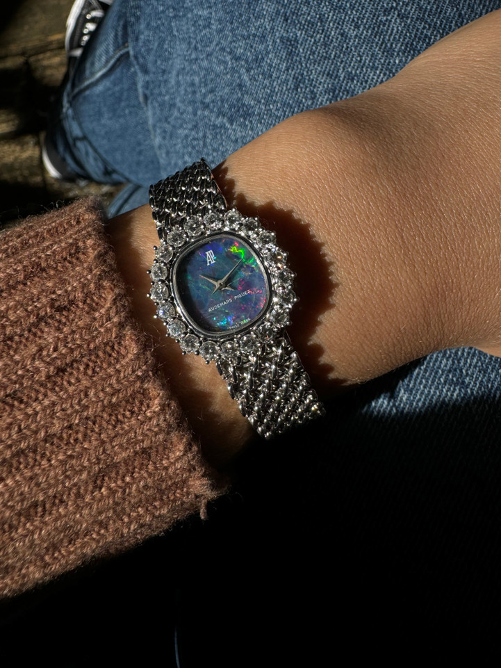 A fine vintage Audemars Piguet opal and diamond bracelet watch in 18k white gold, crafted during the 1980s. A stunning oval accessory for the fiery gem quality opal dial Audemars is renowned in selecting for their fine pieces, surrounded by round brilliant cut diamonds. Both the opal and diamonds catch the light in a way that refracts a glitter of rainbow colors. This piece will dazzle the wearer and suit a variety of occasions, its interlinked chain bracelet wearing comfortably on the wrist. Modeled on 6 inch wrist.

The opal has faint crack at 4 o’clock position that is imperceptible with the naked eye due to the competing opal. Light scratch on center crystal. 
Factory round cut .10 carat diamond set bezel; 2 carats total approximate.
Original opal dial, hands and crown. 
Case measures 21.5 x 22.5 mm, 6.5 mm thick. 
AP cal. 2430, 18 jewel backwind set movement. 
Case# 194xx Movement# 2636xx
Sapphire crystal. 
AP signed bracelet, measures and fits 6 3/4 inches or 17cm approximate, 12mm wide.