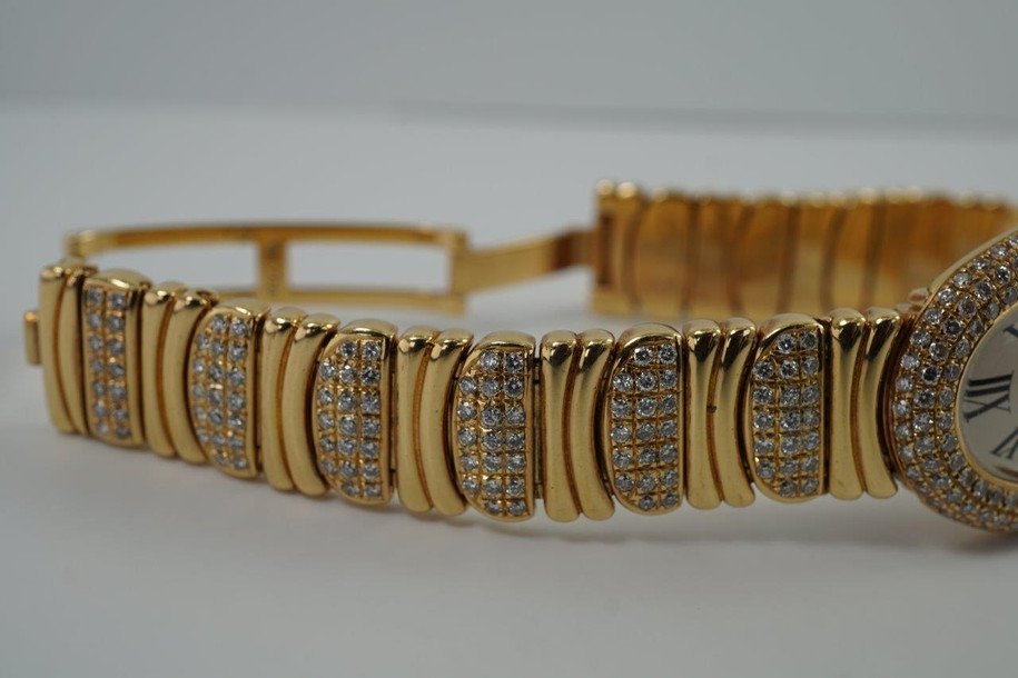 BRAND:                          Cartier
MODEL:                          Baignoire
CASE MATERIAL:           18k yellow gold and diamonds
CASE MEASURES:          22.5 x 30.5 mm
MOVEMENT:                   Quartz
FUNCTIONS:                   Time
CONDITION:                    Fine
See it in our eBay store.

A fine preowned Cartier Baignoire reference 3710 in 18k yellow gold, crafted during the 1980s. A current popular model with a distinctive added detail of the interchanging diamond settings and gold bracelet. Brilliant diamond set bezel and diamond crown encases an off white dial, blue steeled hands and black Roman numerals with hidden Cartier hallmark at 10 o’clock. The bracelet can be converted for a leather strap with ease for a more casual toned down look. Will certainly draw attention to the wearer’s wrist, wearing comfortably with either alternative.  

Light scratches on crystal. 
Original dial, hands and sapphire crown. 
Factory diamond set bezel and bracelet.
Case measures 22.5 x 30.5 mm, 6.5 mm thick. 
Acrylic crystal. 
Cartier quartz movement. 
Serial# 8057xxx
Cartier diamond bracelet fits 5 7/8 inches or 14.5 cm, approximately. Can be sized down.
New non-Cartier black leather strap.
13 lug width.
Modeled on 6 inch wrist.