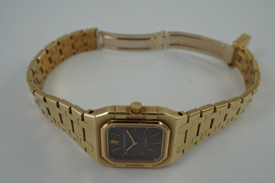 A very nice vintage Audemars Piguet Royal Oak in 18k yellow gold, crafted from the mid to late 1980s. The gold hours, hands and AP hallmark vividly stand out against the dark grey tapisserie dial in the light, complementing the boldness of the square rectangular case and bracelet. A lovely everyday piece that wears comfortably on the wrist with a thin profile and closure. 

Original finish shows normal wear due to use. 
Original tapisserie dial, gold hands and gold crown. 
Case measures 25 x 33 mm. 
AP cal. 2502, 7 Jewel quartz movement.
Serial# B604xx Movement# 213740 
Sapphire crystal. 
Original Audemars bracelet fits 6 1/8 inch or 15.5cm approximate.
18mm lug width. 
Modeled on 6 inch wrist.