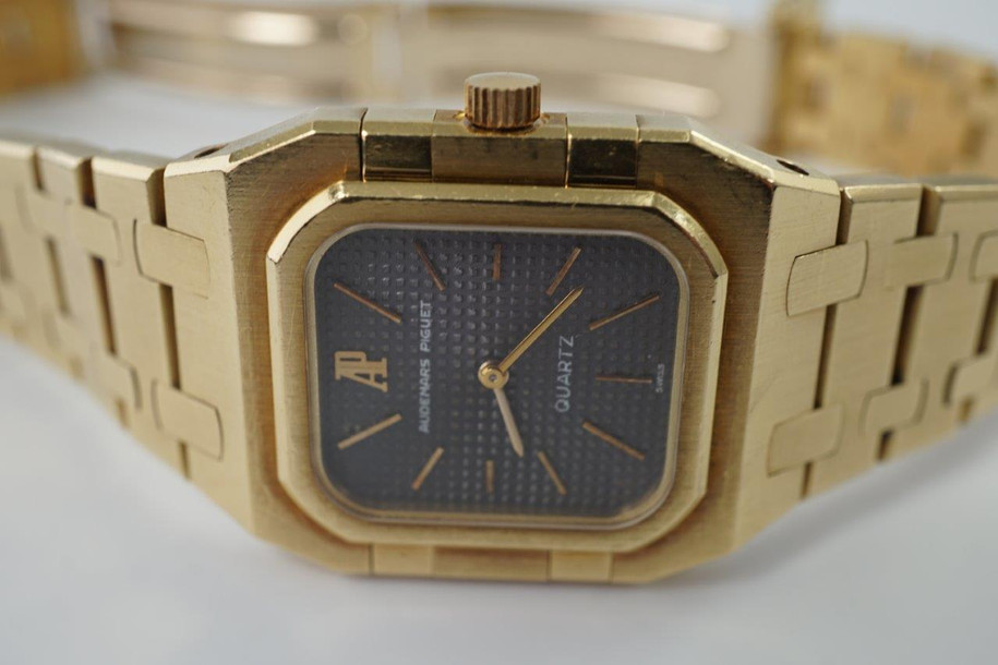 A very nice vintage Audemars Piguet Royal Oak in 18k yellow gold, crafted from the mid to late 1980s. The gold hours, hands and AP hallmark vividly stand out against the dark grey tapisserie dial in the light, complementing the boldness of the square rectangular case and bracelet. A lovely everyday piece that wears comfortably on the wrist with a thin profile and closure. 

Original finish shows normal wear due to use. 
Original tapisserie dial, gold hands and gold crown. 
Case measures 25 x 33 mm. 
AP cal. 2502, 7 Jewel quartz movement.
Serial# B604xx Movement# 213740 
Sapphire crystal. 
Original Audemars bracelet fits 6 1/8 inch or 15.5cm approximate.
18mm lug width. 
Modeled on 6 inch wrist.
