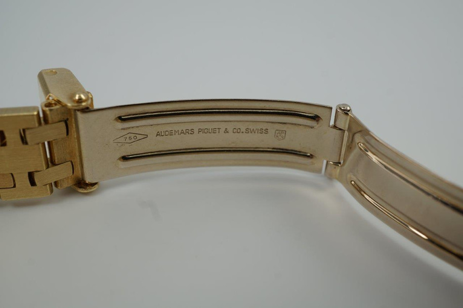 A very nice vintage Audemars Piguet Royal Oak in 18k yellow gold, crafted from the mid to late 1980s. The gold hours, hands and AP hallmark vividly stand out against the dark grey tapisserie dial in the light, complementing the boldness of the square rectangular case and bracelet. A lovely everyday piece that wears comfortably on the wrist with a thin profile and closure. 

Original finish shows normal wear due to use. 
Original tapisserie dial, gold hands and gold crown. 
Case measures 25 x 33 mm. 
AP cal. 2502, 7 Jewel quartz movement.
Serial# B604xx Movement# 213740 
Sapphire crystal. 
Original Audemars bracelet fits 6 1/8 inch or 15.5cm approximate.
18mm lug width. 
Modeled on 6 inch wrist.