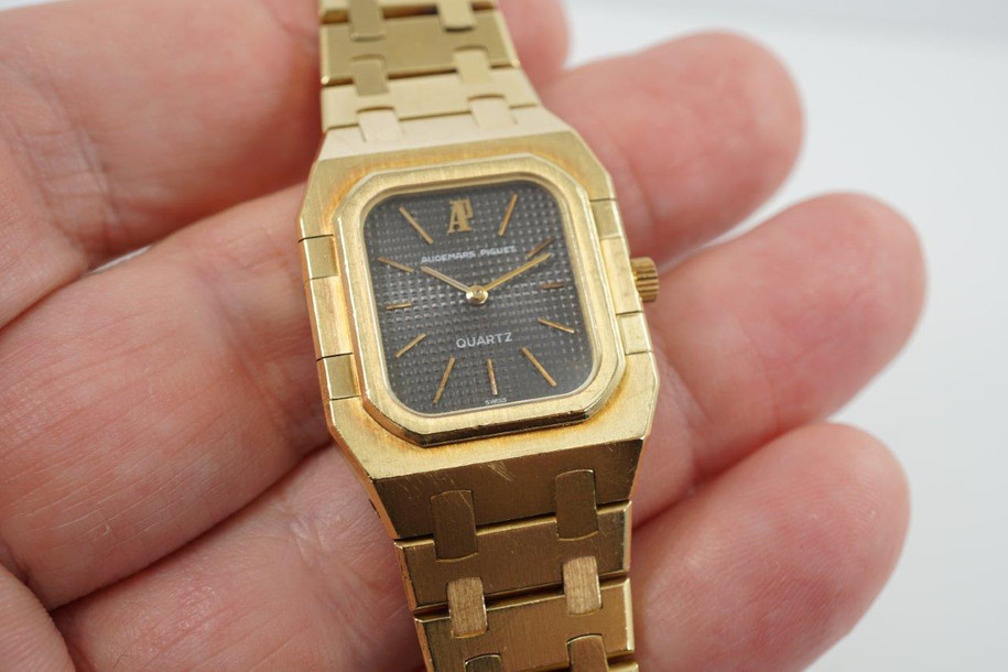 A very nice vintage Audemars Piguet Royal Oak in 18k yellow gold, crafted from the mid to late 1980s. The gold hours, hands and AP hallmark vividly stand out against the dark grey tapisserie dial in the light, complementing the boldness of the square rectangular case and bracelet. A lovely everyday piece that wears comfortably on the wrist with a thin profile and closure. 

Original finish shows normal wear due to use. 
Original tapisserie dial, gold hands and gold crown. 
Case measures 25 x 33 mm. 
AP cal. 2502, 7 Jewel quartz movement.
Serial# B604xx Movement# 213740 
Sapphire crystal. 
Original Audemars bracelet fits 6 1/8 inch or 15.5cm approximate.
18mm lug width. 
Modeled on 6 inch wrist.