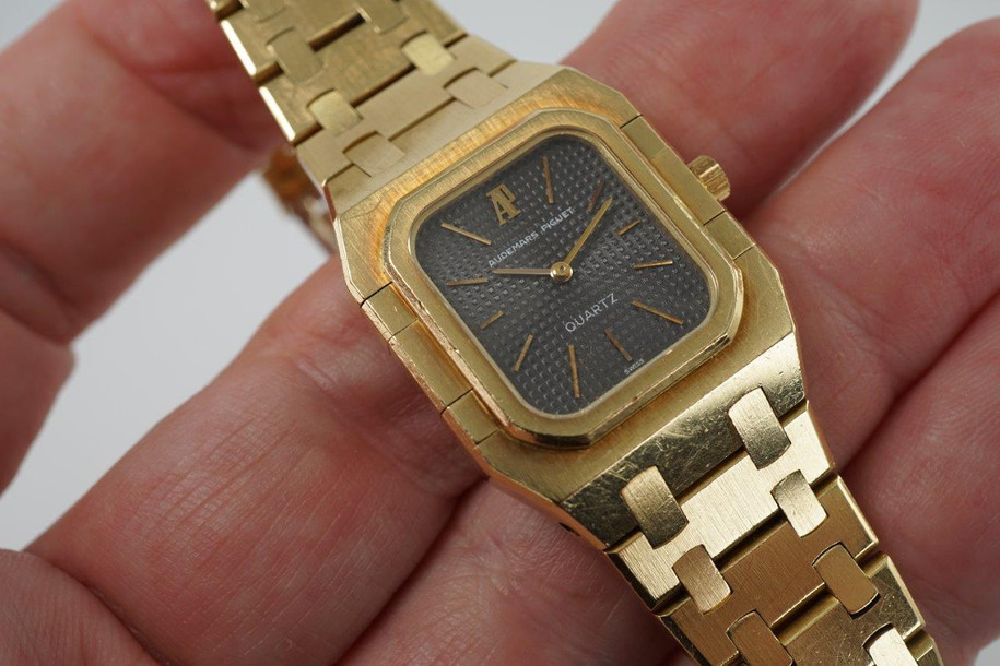 A very nice vintage Audemars Piguet Royal Oak in 18k yellow gold, crafted from the mid to late 1980s. The gold hours, hands and AP hallmark vividly stand out against the dark grey tapisserie dial in the light, complementing the boldness of the square rectangular case and bracelet. A lovely everyday piece that wears comfortably on the wrist with a thin profile and closure. 

Original finish shows normal wear due to use. 
Original tapisserie dial, gold hands and gold crown. 
Case measures 25 x 33 mm. 
AP cal. 2502, 7 Jewel quartz movement.
Serial# B604xx Movement# 213740 
Sapphire crystal. 
Original Audemars bracelet fits 6 1/8 inch or 15.5cm approximate.
18mm lug width. 
Modeled on 6 inch wrist.