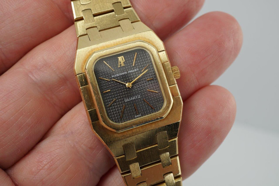 A very nice vintage Audemars Piguet Royal Oak in 18k yellow gold, crafted from the mid to late 1980s. The gold hours, hands and AP hallmark vividly stand out against the dark grey tapisserie dial in the light, complementing the boldness of the square rectangular case and bracelet. A lovely everyday piece that wears comfortably on the wrist with a thin profile and closure. 

Original finish shows normal wear due to use. 
Original tapisserie dial, gold hands and gold crown. 
Case measures 25 x 33 mm. 
AP cal. 2502, 7 Jewel quartz movement.
Serial# B604xx Movement# 213740 
Sapphire crystal. 
Original Audemars bracelet fits 6 1/8 inch or 15.5cm approximate.
18mm lug width. 
Modeled on 6 inch wrist.