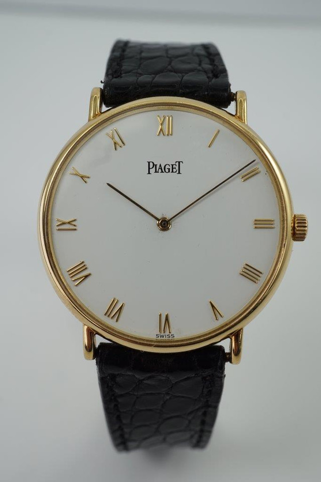 A very nice preowned Piaget watch in 18k yellow gold reference 8035, crafted during the 1990-2000s. A classic configuration of understated gold round smooth case, white dial and gold applied hours and Roman numerals. This piece will take you from executive look to a casual occasion, featuring an ultra-thin profile and paired with a black strap. Suitable for men or women.

Minimal scratches. 
Original dial, hands and crown.
Case measures 32.5 x 35 mm, 4.5mm thick. 
Piaget cal. 858P quartz movement. 
Case# 594500 Movement# 9901021 
Sapphire crystal. 
Piaget black crocodile strap (80% condition approximate).
Piaget 18k gold buckle.
17mm lug width.