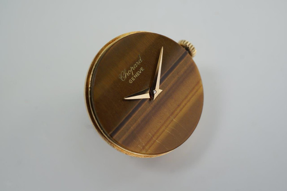 A beautiful vintage Chopard ladies stirrup style watch in 18k yellow gold, crafted circa 1970s. A stunning accessory featuring an eye-catching tiger eye face encased in an oval case, fastened to stirrup hoop style lugs and an understated leopard strap tonally complementing the tiger eye. The stirrup hoop with slim strap reminiscent of Hermes and Gucci, a popular style during its time, wears comfortably on the wrist and would suit a variety of occasions. 

Light scratches on case, natural striations on stone dial.
Original tiger eye dial, hands and L.U.C. crown. 
Case measures 23 x 25mm, 69mm stirrup end to end, 7mm thick.
Chopard L.U.C. cal. 2512 ETA, 17 jewel mechanical winding.
Case# 937xx
Sapphire crystal.
Leather print strap, believed to be the original style (70% condition approximate). 
Gold plated buckle.
11mm lug width.
Modeled on 6 inch wrist.