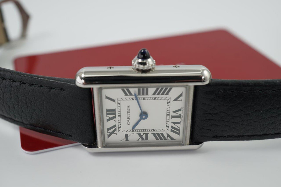 A fine Cartier Tank Must reference WSTA0042 in stainless steel, produced in 2023. A complete set with boxes and card, this enduring accessory from Cartier’s iterations of Tank models features the standard silvered dial, secret Cartier logo at 10 o’clock, black Roman numerals and chemin de fer, blued-steel sword-shaped hands and elongated blue spinel cabochon beaded crown. Classic and simple configuration of steel case and black leather strap will suit a variety of occasions with a comfort fit. 

Minimal scratches. 
Original dial, hands and crown. 
Case measures 22 x 30mm, 7mm thick.
Serial# 4322361xxxX
16 mm lug width. 
Cartier black leather strap (95% condition approximate). 
Cartier steel tang buckle.
16mm lug width.
Modeled on a 6 inch wrist.
