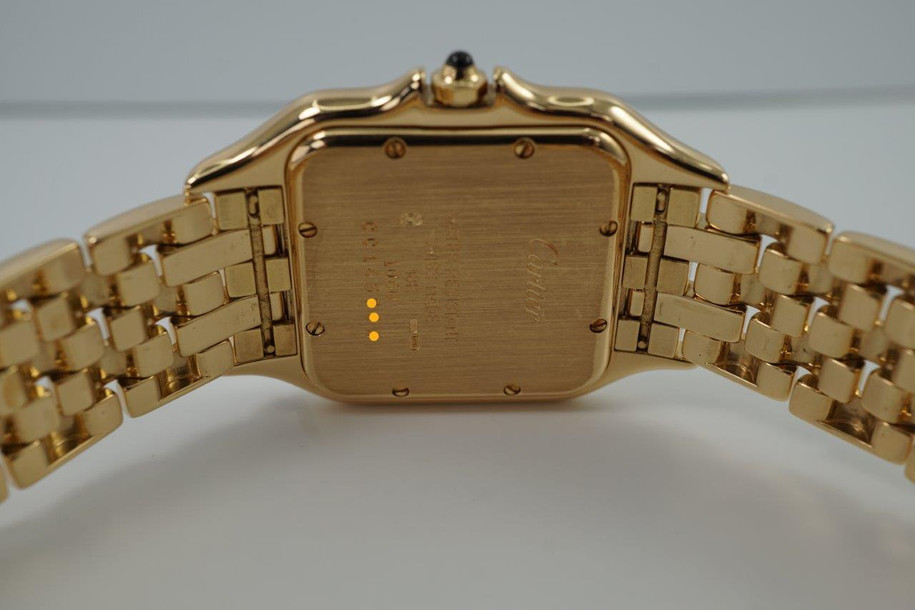 A fine Cartier Panthere reference 1060 in 18k yellow gold, crafted during the 1990s. In near mint condition, this accessory features a white dial, black Roman numerals and chemin de fer, blued steel sword hands, date aperture and inconspicuous written Cartier at 10 o’clock with a blue spinel cabochon. Wears as jewelry for its beautiful gold bracelet with hidden clasp and low silhouette square case for a comfort fit. From day to night, suitable for all dress occasions for either a man or woman. 

Original box shows interior wear. 
Original dial, hands and crown. 
Case measures 28 x 38mm, 6mm thick.
Sapphire crystal. 
Serial# CC165xxx
Cartier 18k yellow gold bracelet, full size and tight bracelet with no stretch (fits 7 1/4 inch or 18.4 cm). 
15mm lug width.
Modeled on a 6 inch wrist.