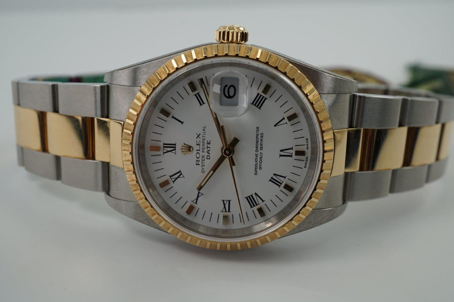 A fine new old stock Rolex Date reference 15223 in 18k yellow gold and stainless steel, crafted circa 2005. In unpolished condition, as if it left the Rolex boutique with tags attached and very little wear, if any, shown and still adhered original Rolex stickers. Featuring a 34.5 mm two-tone case housing a white dial with gold applied hour markers and hands, black numeral hours and minute markers, with date aperture, engine turned gold bezel and a two-tone oyster bracelet with adjustable fold clasp. A popular and enduring model to wear for various occasions.