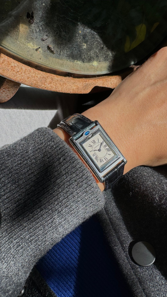 A nice preowned Cartier Basculante reference 2386 with Cartier papers, crafted circa 2001. This is a curious design modeled after their first Cabriolet model from 1932 for its intended functionality during physical activity, so that the crystal is protected, as such the crown placement is allocated to the 12 o’clock position with a horizontal blue oval cabochon charmingly sitting on top. The dial is the standard silvered dial with black Roman numeral markers and inner chemin de fer minute track, secret Cartier signature at 10 o’clock and blued-steel sword-shaped hands. The inner polished case housing said dial is configured into a swing frame, movable in either forward or reverse direction, revealing double C signatures on the inner case back and a smooth steel topper. While this function may not pertain to today’s needs, it is a fascinating detail that sets it apart from the regular Tank models and manages to sit relatively flush on the wrist.