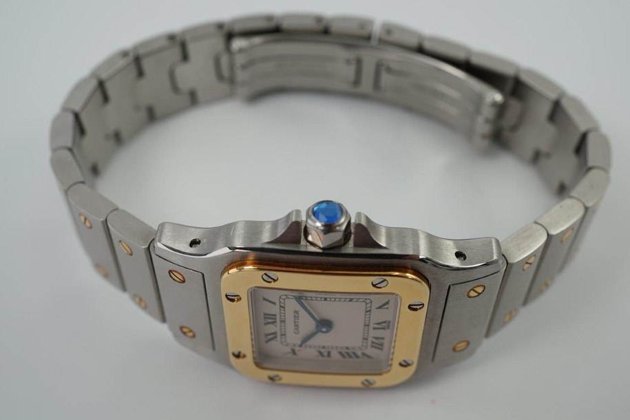 A very nice preowned Cartier Santos Galbee in stainless steel and 18k yellow gold reference 1567, crafted during the 1990s. A lovely everyday piece for casual affairs with a luxurious touch from the polished gold bezel with screws contrasting against the brushed 23.5 mm case and bracelet. Features the classic silvered dial, black Roman numeral hours with inconspicuous Cartier logo at 10 o’clock, inner chemin de fer minute track, blued-steel sword-shaped hands and faceted blue spinel crown. The 6 mm silhouette with its double folded seamless clasp allows for ease of wear.