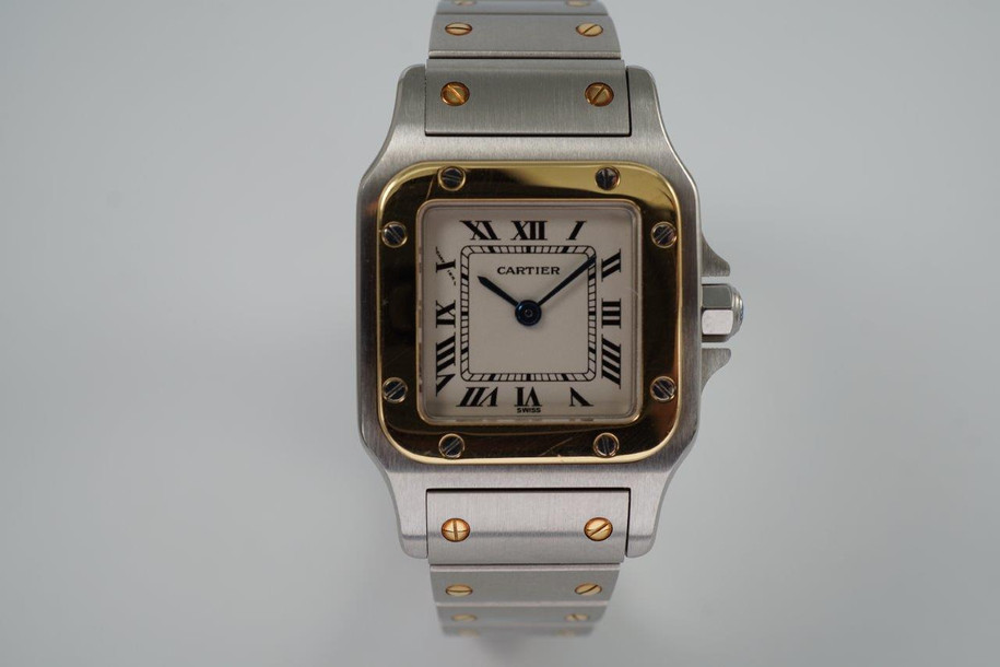 A very nice preowned Cartier Santos Galbee in stainless steel and 18k yellow gold reference 1567, crafted during the 1990s. A lovely everyday piece for casual affairs with a luxurious touch from the polished gold bezel with screws contrasting against the brushed 23.5 mm case and bracelet. Features the classic silvered dial, black Roman numeral hours with inconspicuous Cartier logo at 10 o’clock, inner chemin de fer minute track, blued-steel sword-shaped hands and faceted blue spinel crown. The 6 mm silhouette with its double folded seamless clasp allows for ease of wear.